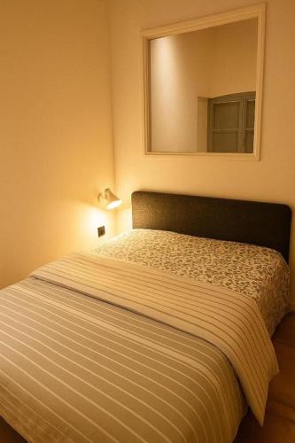 un letto in una piccola stanza con specchio di Studio Entièrement Rénové Rue Grande Haute, Sète a Sète
