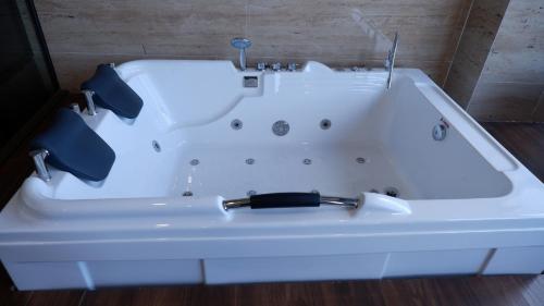 a white bath tub with a black handle at MD Hotel in Mỹ Lộc