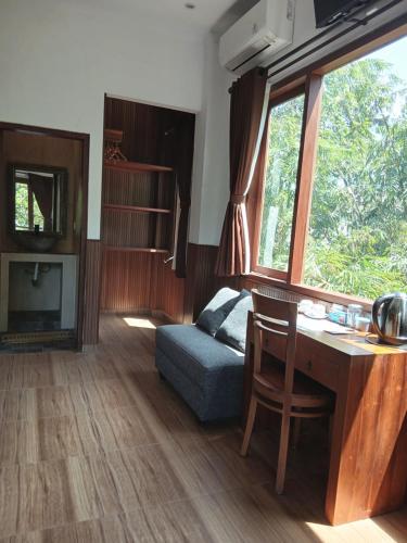 a living room with a desk and a blue couch at In KARMA in Ubud