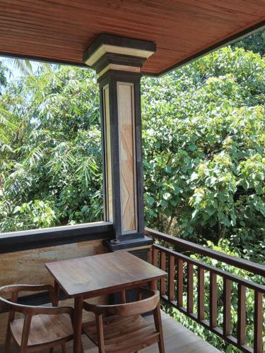 a table and chairs on a balcony with trees at In KARMA in Ubud