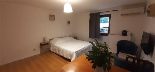 a bedroom with a bed and a table and a window at Au relais des ballons in Saint-Maurice-sur-Moselle