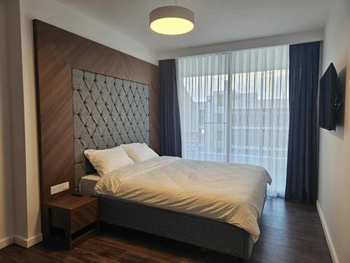 a bedroom with a bed and a large window at Holiday Apartments at Grand Sapphire Residence in Saint Yeorgios