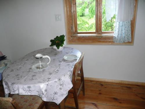 une table à manger avec un chiffon de table blanc et une fenêtre dans l'établissement Mazurska Perła, à Jaśkowo