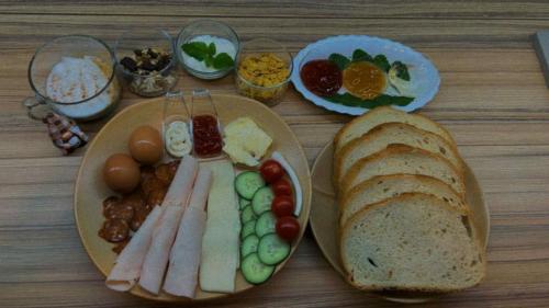 a table with two plates of food with meats and bread at FLÓRA VENDÉGHÁZ A BALATONNÁL in Lovas