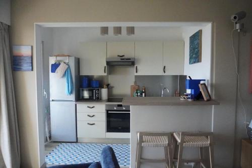 a small kitchen with a refrigerator and a table and chairs at Casa Mare - Sea View, Home Cinema, Parking in Menton