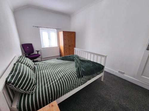 a bedroom with a bed and a window and a chair at The Maple in Grays Thurrock