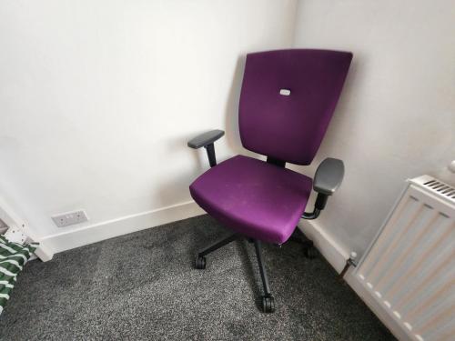 a purple chair sitting in a corner of a room at The Maple in Grays Thurrock