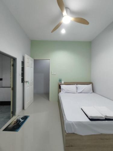 a bedroom with a bed and a ceiling fan at Krabi Rooms in Ban Khlong Chi Lat