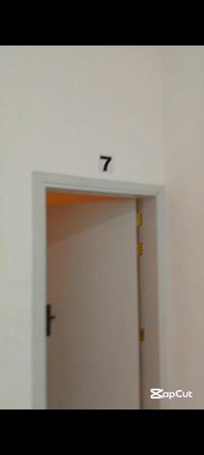 Una puerta con el número siete encima en غرفة بمطبخ وحمام خاص, en Al Ḩuwayl