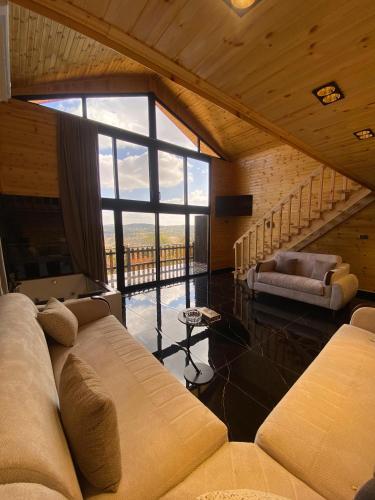 a living room with a couch and a large window at منتجع غروب الشمس in Ajloun