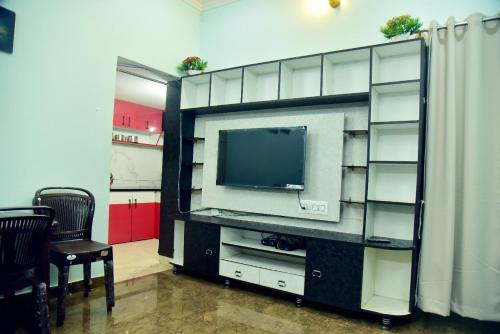 a entertainment center with a television in a room at Mysuru Family Home Stay in Mysore