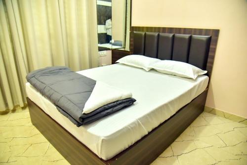 a bedroom with a large bed with white sheets and pillows at Mysuru Family Home Stay in Mysore