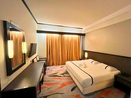 a hotel room with a large bed and a window at Seeds Hotel Premier Sri Petaling in Kuala Lumpur