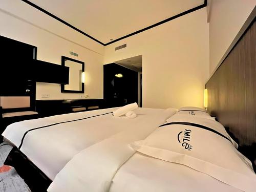 a bedroom with a bed with white sheets at Seeds Hotel Premier Sri Petaling in Kuala Lumpur