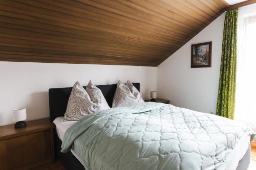 a bedroom with a large bed with a wooden ceiling at Haus Sophie in Admont