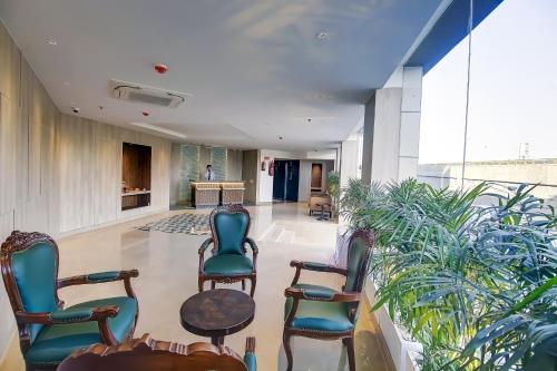 a hallway with chairs and plants in a building at OPO Premium - Free Pickup delhi Airport in New Delhi