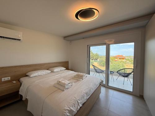 a bedroom with a bed and a sliding glass door at Artline City Apartment in Nea Moudania