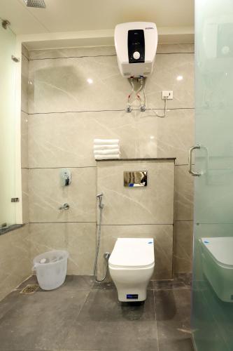 a bathroom with a toilet and a camera on the wall at OPO Premium - Free Pickup delhi Airport in New Delhi