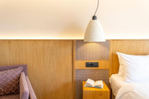 a bedroom with a bed and a book on a table at ELIXIA in Tolo