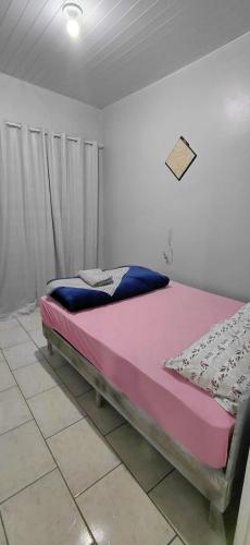 a bed in a room with a pink and blue mattress at Pousada familiar 06 in Rio do Sul