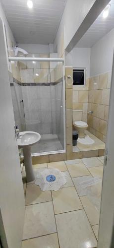 a bathroom with a shower and a sink and a toilet at Pousada familiar 06 in Rio do Sul