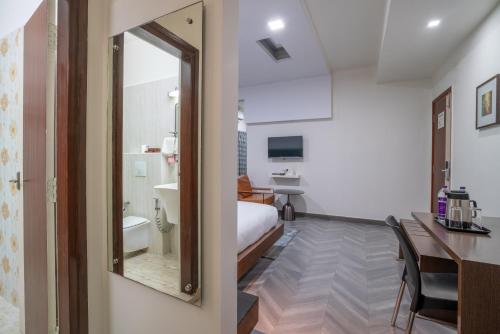 una camera da letto con un letto, una scrivania e uno specchio di Hotel Serenity La Vista a Hyderabad