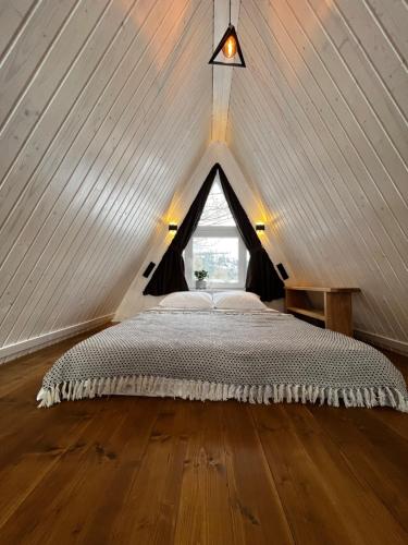 a bedroom with a bed in a attic at Riverview cottage in Pilipets