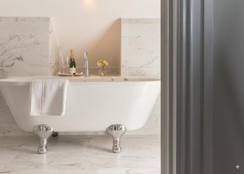 a white bath tub in a bathroom with a sink at Bathen House Boutique Hotel in Bath