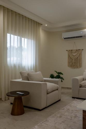 a living room with a white couch and a table at Welhome Stays Aparthotel in Cairo