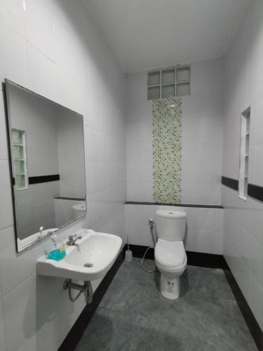a bathroom with a white toilet and a sink at Krabi Rooms in Ban Khlong Chi Lat