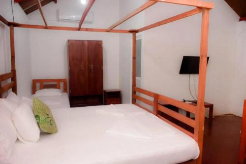 a bedroom with two bunk beds and a tv at Sinharaja Forest Sanctuary in Deniyaya