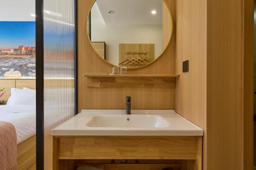 a bathroom with a sink and a mirror at Floral Hotel Beidaihe Migao Intelligent Hotel in Qinhuangdao