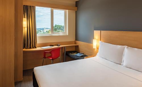 A bed or beds in a room at ibis Chapeco