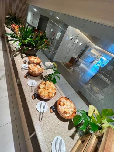 a table with several plates of food on it at Refúgio do Mar 705 - Condomínio Edifício Ritz Suítes Home Service in Maceió