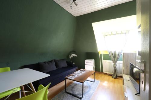 a living room with a blue couch and a table at Green Seeblick Hotel am See in Obermaubach