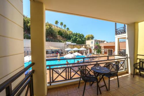 a balcony with a view of a swimming pool at Porto Kalamaki Hotel in Kalamaki Chanion