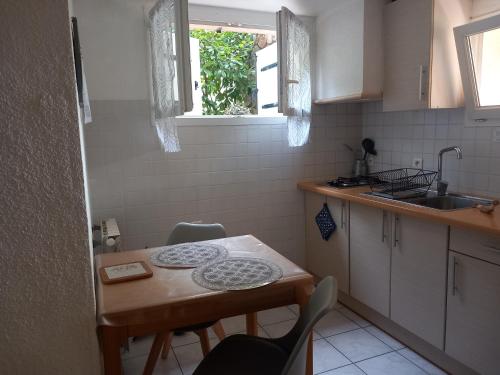 une petite cuisine avec une table et un évier dans l'établissement Studio meublé indépendant tout confort classé 2**, à Aubenas