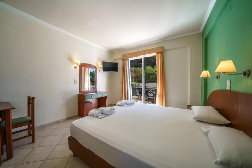 a bedroom with a large bed and a window at Porto Kalamaki Hotel in Kalamaki Chanion