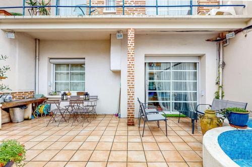 Un patio con sillas y una mesa en una casa. en St Agne 3 min du métrobus - Patio - bassin, en Toulouse