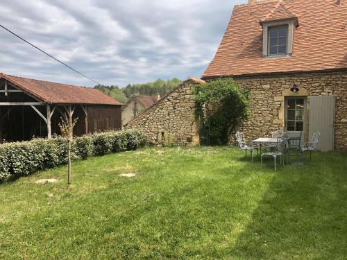 a house with a table and chairs in a yard at Maison en pierre avec jardin et piscine privée, proche Trémolat - FR-1-824-21 in Paunat