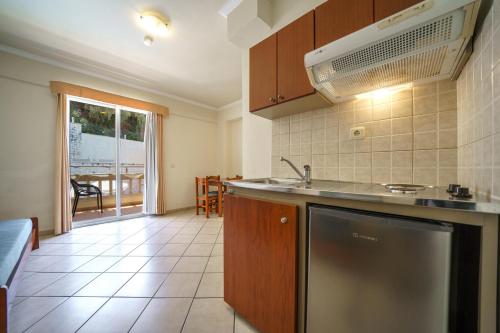 a kitchen with a sink and a dishwasher at Porto Kalamaki Hotel in Kalamaki Chanion