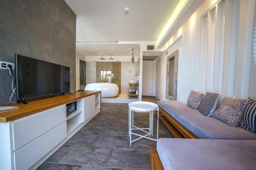 a living room with a couch and a flat screen tv at Porto Kalamaki Hotel in Kalamaki Chanion