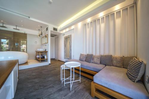 a living room with a couch and a bath tub at Porto Kalamaki Hotel in Kalamaki Chanion
