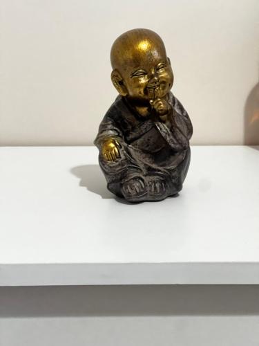 a bronze statue of a monk sitting on a table at Dyrrah G In the heart of Durres in Durrës