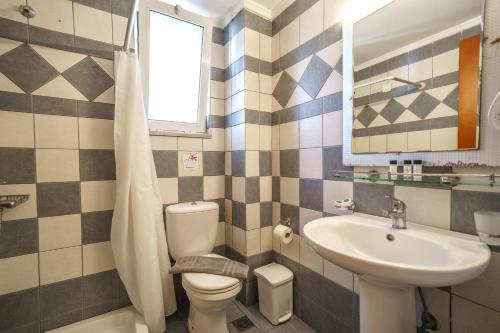 a bathroom with a toilet and a sink at Porto Kalamaki Hotel in Kalamaki Chanion