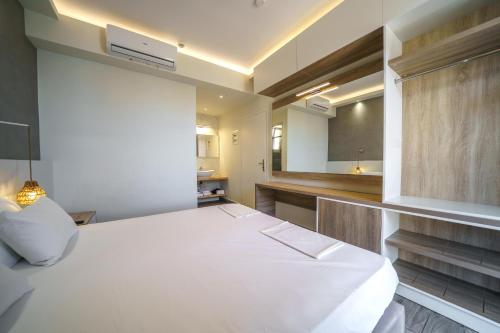 a large white bed in a room with a kitchen at Porto Kalamaki Hotel in Kalamaki Chanion