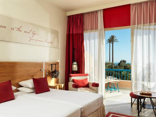 a hotel room with a bed and a balcony at Club Paradisio El Gouna Red Sea in Hurghada