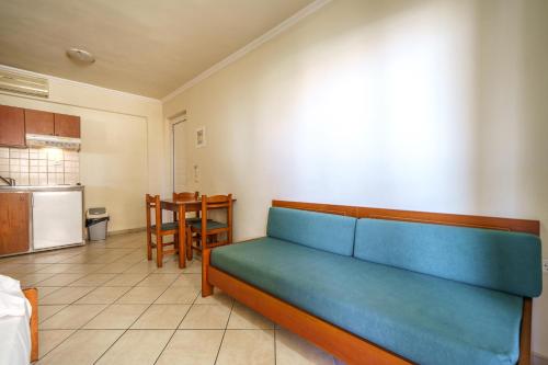 a blue couch in a room with a kitchen at Porto Kalamaki Hotel in Kalamaki Chanion