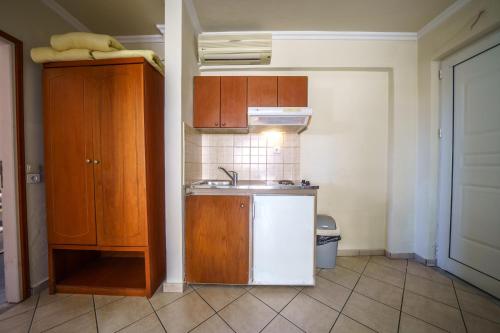 a small kitchen with a sink and a refrigerator at Porto Kalamaki Hotel in Kalamaki Chanion
