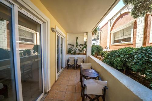 a balcony with chairs and a table on a building at Porto Kalamaki Hotel in Kalamaki Chanion